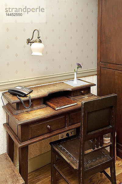 Modernes Telefon auf einem altmodischen Schreibtisch