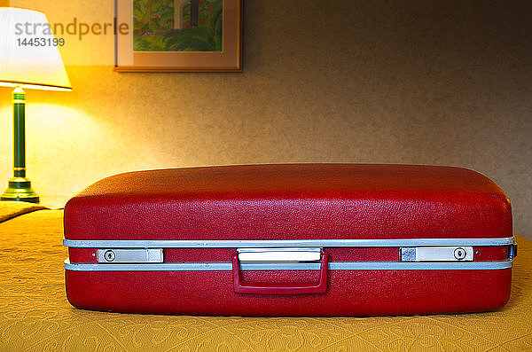 Roter Koffer im Motelzimmer