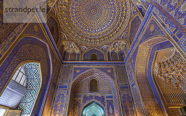 Das Innere einer Madrasa  dekoriert mit blau-weißen und goldenen Keramikfliesen in traditionellen islamischen Mustern in Samarkand.