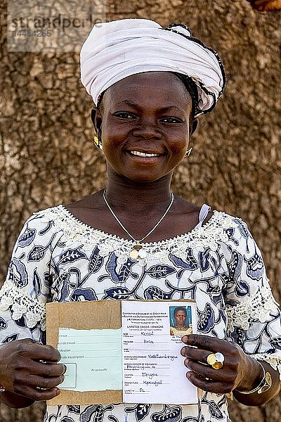 Mitglied einer Mikrofinanzgenossenschaft von Frauen zeigt ihr Sparbuch im Norden Togos.