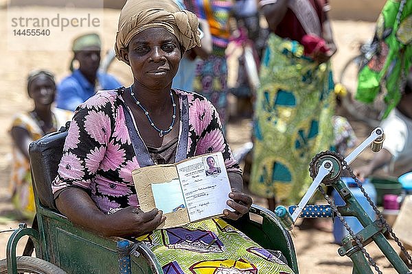 Ein behindertes Mitglied einer Mikrofinanzgenossenschaft für Frauen zeigt ihr Sparbuch im Norden Togos.