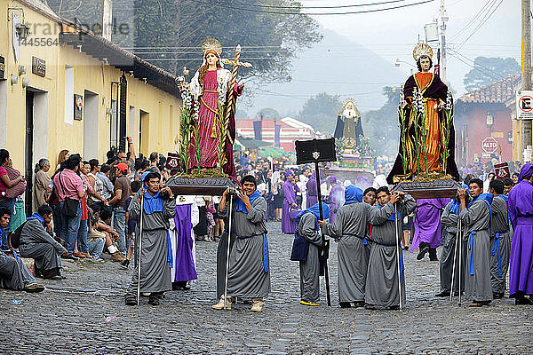 Büßer tragen das Bild eines Heiligen bei der Prozession von Jesus Nazareno del Perdon in der Karwoche  Antigua  Guatemala  Mittelamerika.