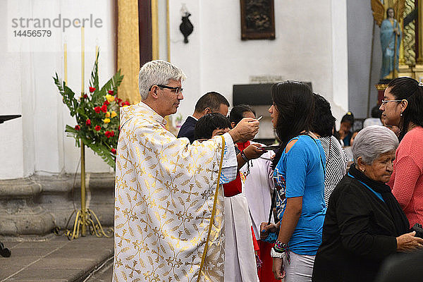 Priester bei der Kommunionspendung während der Osterfeier in der Kirche La Merced  Antigua  Guatemala  Mittelamerika.