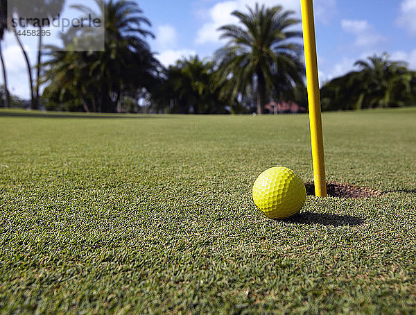 Neben dem Loch liegender Golfball