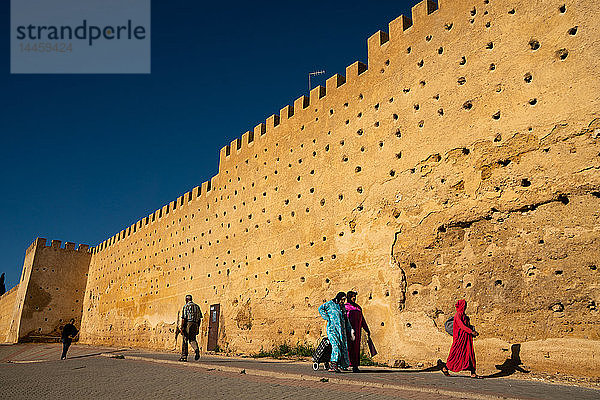 Frauen in traditioneller Kleidung gehen entlang der Mauern der Kasbah Cherada in der Medina von Fes  UNESCO-Weltkulturerbe  Marokko  Nordafrika