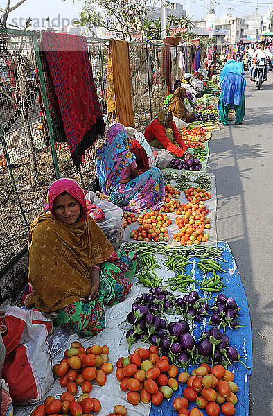 Frauen auf dem Straßenmarkt eines Dorfes  die auf Säcken ausgelegtes selbst angebautes Gemüse verkaufen  Chhota Udepur  Gujarat  Indien