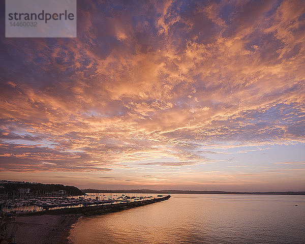 Bunte Sonnenuntergangsansicht von Breakwater Beach und der Hafenmauer von Brixham  Devon  England  Vereinigtes Königreich