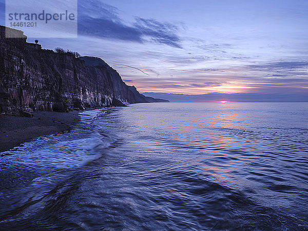 Die Sonne lugt unter einer Wolkenbank in Sidmouth  Devon  England  Vereinigtes Königreich hervor