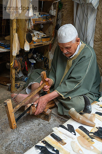 Mann sägt Horn  um Kämme in einer Gasse in der Altstadt (Medina) von Fes  UNESCO-Weltkulturerbe  Marokko  Nordafrika  herzustellen