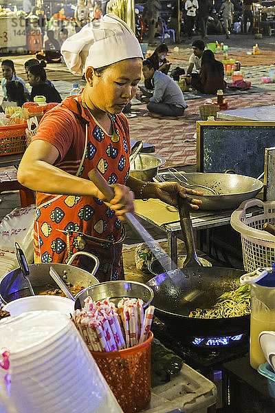 Koch brät Nudeln in einem Wok auf dem Phsar Kandal Nachtmarkt in der Nähe des Flussufers  Phsar Kandal  Stadtzentrum  Phnom Penh  Kambodscha  Indochina  Südostasien