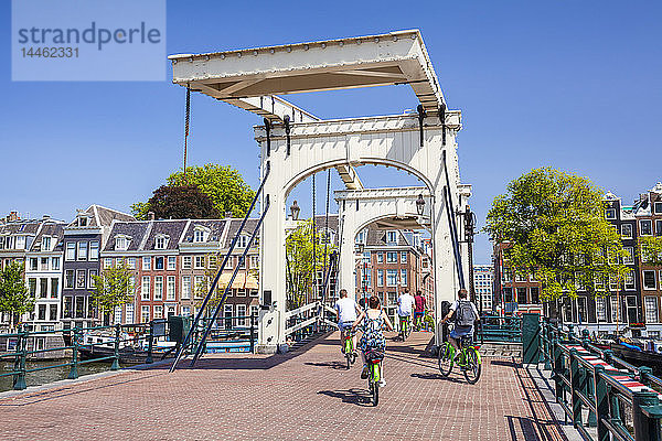 Radfahrer fahren über die Magere brug (dünne Brücke)  die den Fluss Amstel überspannt  Amsterdam  Nordholland  Niederlande