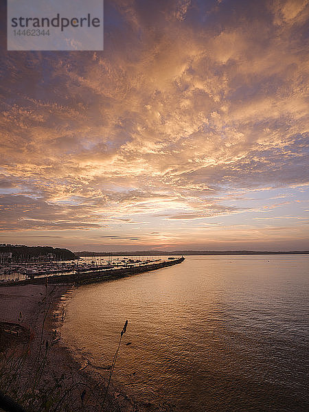 Bunte Sonnenuntergangsansicht von Breakwater Beach und der Hafenmauer von Brixham  Devon  England  Vereinigtes Königreich