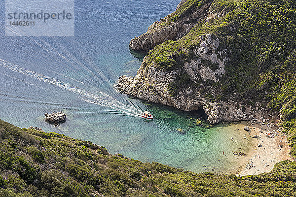 Blick aus der Vogelperspektive auf einen der Strände von Porto Timoni und ein Taxiboot  das sich der Bucht nähert  Afionas  Korfu  Griechische Inseln  Griechenland
