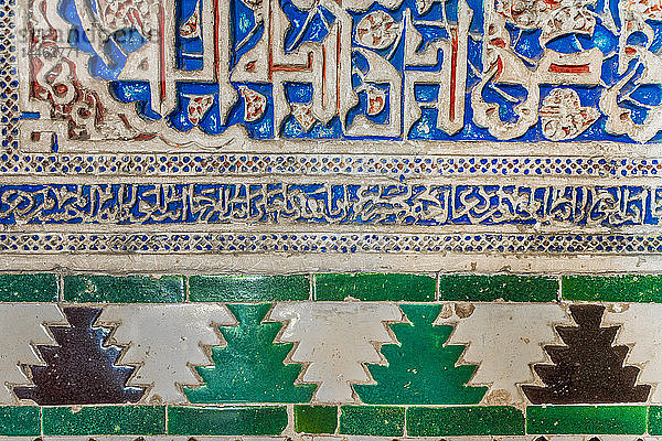 Nahaufnahme von arabischen Wandschnitzereien und bunten Fliesen mit islamischen Inschriften  Real Alcazar  UNESCO-Weltkulturerbe  Sevilla  Andalusien  Spanien