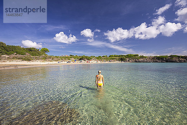 Ein Mädchen im Badeanzug spaziert im Wasser  Strand La Bobba  Insel San Pietro  Provinz Sud Sardegna  Sardinien  Italien  Mittelmeer
