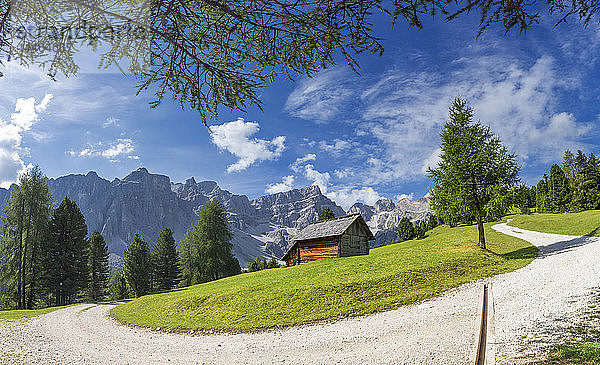 Weißer Weg mit traditioneller Hütte und Puez-Gruppe im Hintergrund  Longiaru  Gadertal  Südtirol  Dolomiten  Italien