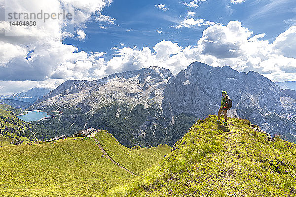 Wanderer schaut zur Viel del Pan Hütte mit Marmolada im Hintergrund  Pordoi Pass  Fassatal  Trentino  Dolomiten  Italien