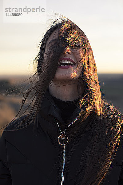 Porträt einer lachenden Teenagerin bei Sonnenuntergang