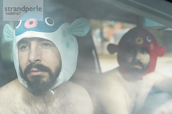 Porträt eines schwulen Paares in einem Auto mit Tierhüten