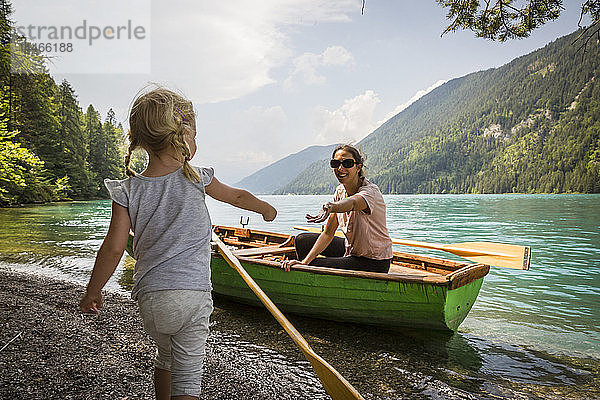 Österreich  Kärnten  Weissensee  Mutter im Ruderboot mit Tochter am Seeufer