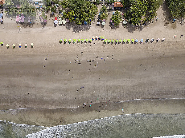 Bali  Kuta Beach  Reihe von Sonnenschirmen und Menschen am Strand  Luftaufnahme