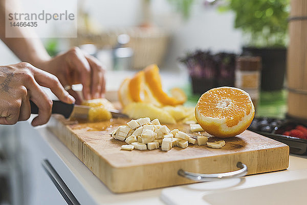 Frau bereitet Obst auf dem Schneidebrett zu