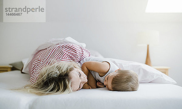 Mutter und Kleinkind Sohn liegen zu Hause im Bett