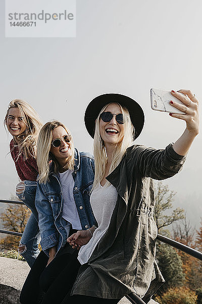 Deutschland  Schwarzwald  Sitzenkirch  drei glückliche junge Frauen  die auf Schloss Sausenburg ein Selfie machen
