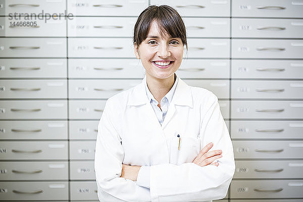 Porträt eines lächelnden Apothekers am Kabinett in der Apotheke