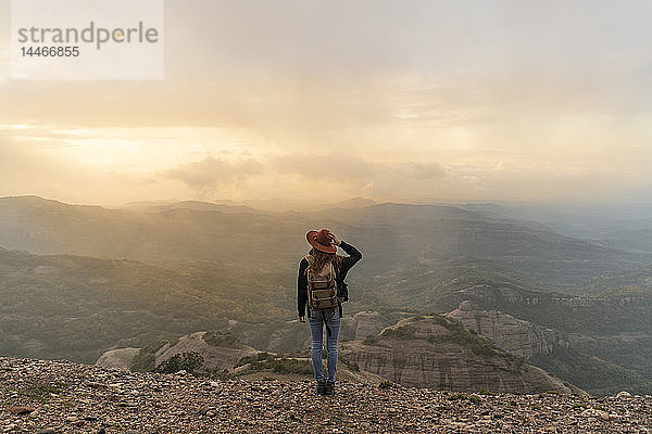 Frau mit Rückenlehne  auf Berg stehend  schaut auf Aussicht