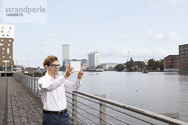 Deutschland  Berlin  Geschäftsmann beim Fotografieren mit einem digitalen Tablett