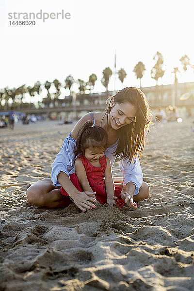 Mutter und Tochter spielen am Strand