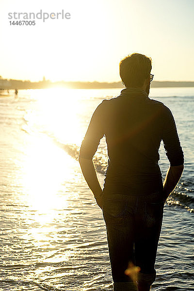 Silhouette eines Mannes  Spaziergang am Strand bei Sonnenuntergang  Rückansicht