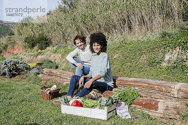 Ehepaar sitzt in seinem Gemüsegarten und macht nach der Ernte ein Picknick
