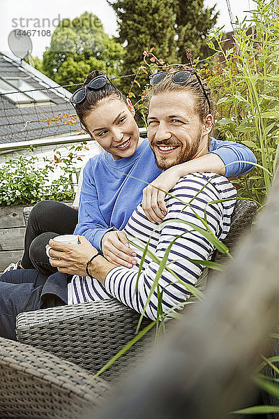 Junges Paar entspannt sich auf dem Balkon  auf der Couch sitzend