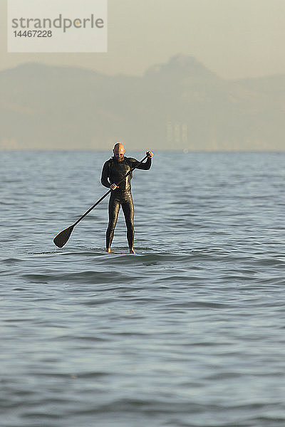 Spanien  Andalusien  Tarifa  Mann steht auf  paddelt auf dem Meer