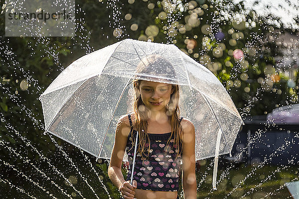 Porträt eines tagträumenden Mädchens mit Regenschirm