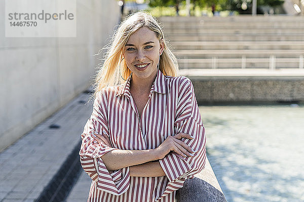 Porträt einer lächelnden blonden Frau mit gestreiftem Hemd