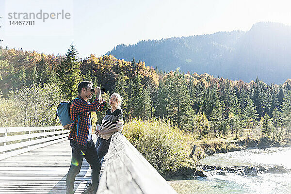 Österreich  Alpen  Ehepaar auf einer Wanderung mit Mann  der durch ein Fernglas schaut