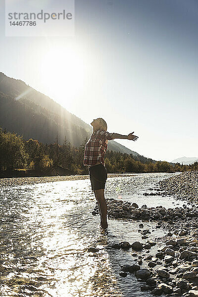 Österreich  Alpen  Frau auf einer Wanderung im Bach stehend