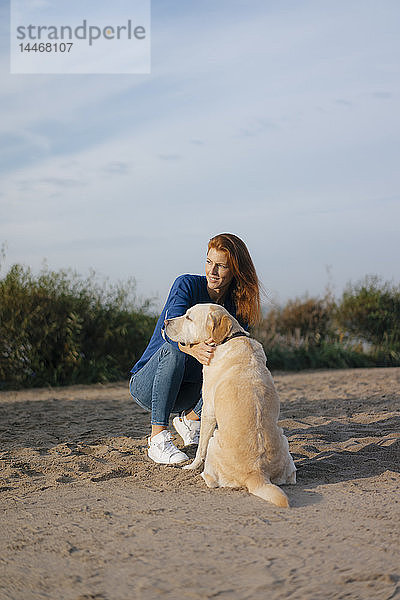 Deutschland  Hamburg  Frau mit Hund am Strand am Elbufer