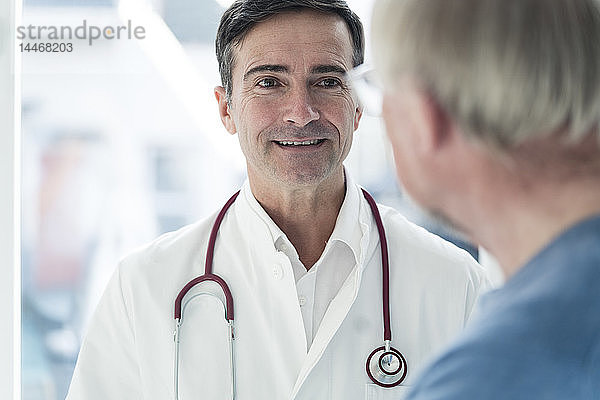 Porträt eines lächelnden Arztes  der den Patienten anschaut