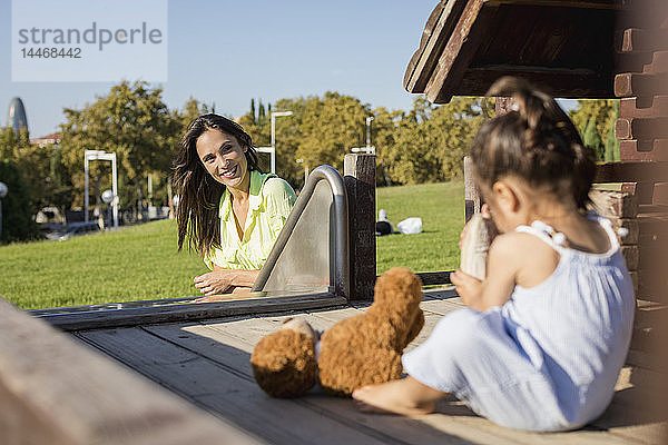 Lächelnde Mutter mit Tochter auf einem Spielplatz