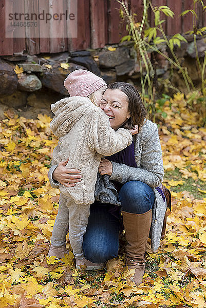 Finnland  Kuopio  Mutter und kleine Tochter kuscheln im Herbst zusammen