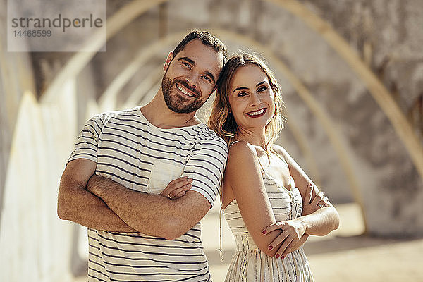 Spanien  Andalusien  Malaga  Porträt eines glücklichen Touristenpaares unter einem Torbogen in der Stadt