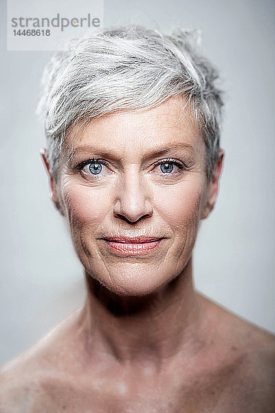 Bildnis einer reifen Frau mit kurzen grauen Haaren und blauen Augen