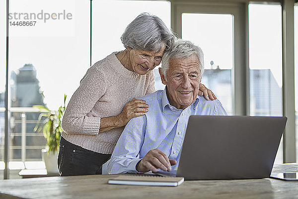 Portrait eines lächelnden älteren Paares mit Laptop