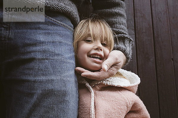 Porträt eines blonden kleinen Mädchens neben ihrem Vater stehend