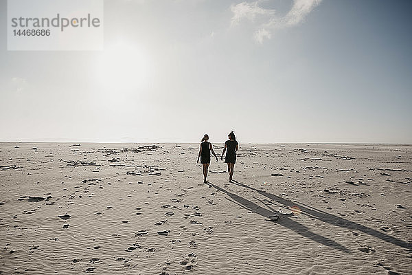 Südafrika  Westkap  Strand von Noordhoek  Rückenansicht zweier junger Frauen beim Strandspaziergang