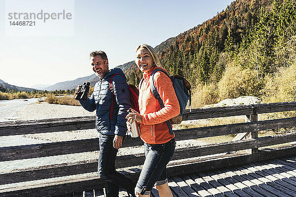 Österreich  Alpen  glückliches Paar auf einer Wanderung über eine Brücke